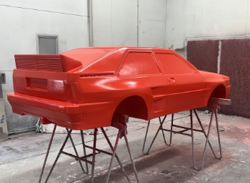 EPS-autovorm met rode coating in spuitcabine bij De la Roy