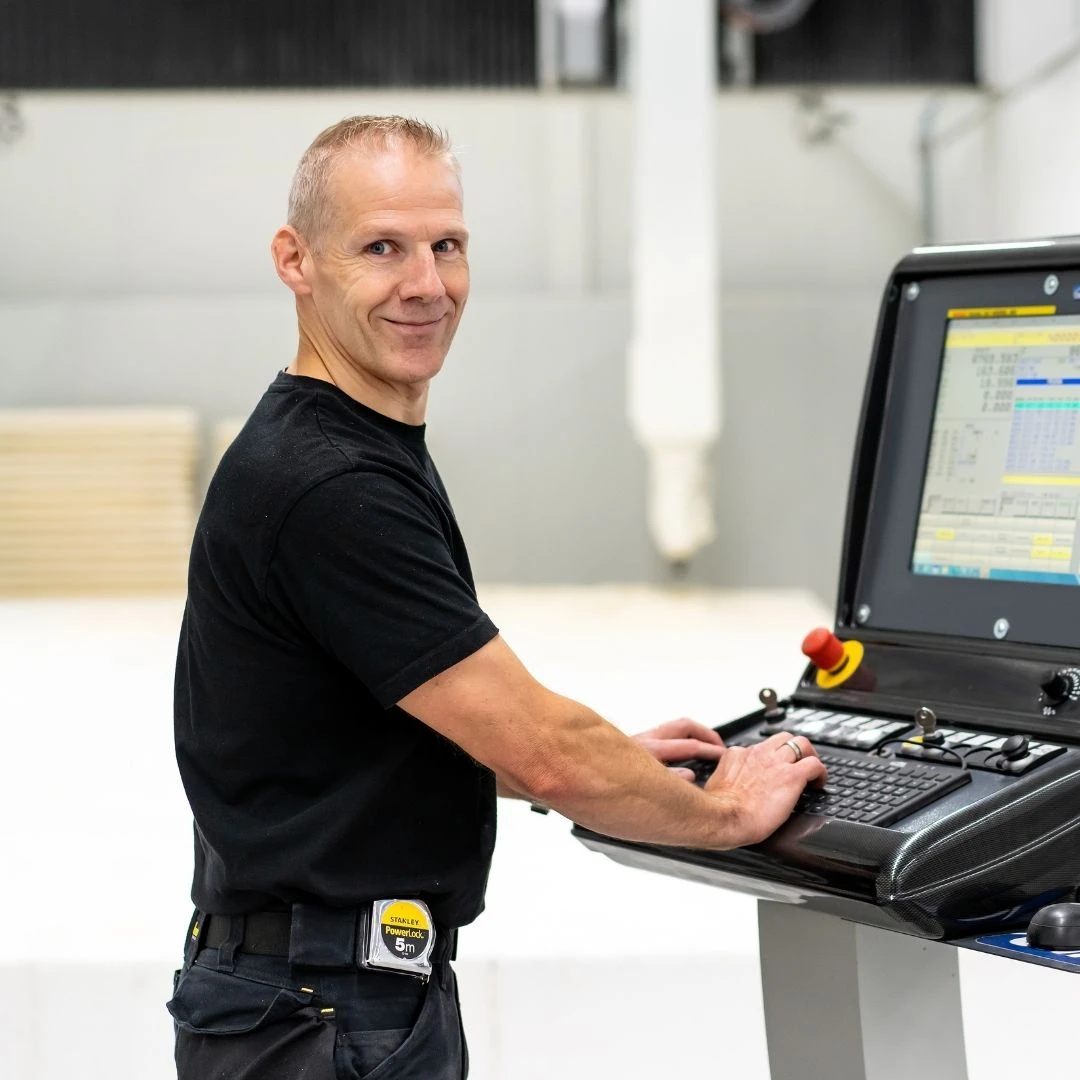 Ronald van Vugt draagt de bedrijfskleding van De la Roy en bedient de contoursnijmachine.