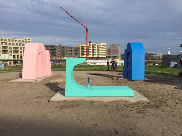 De sculpturen in groen, roze en blauw aangebracht op de locatie.